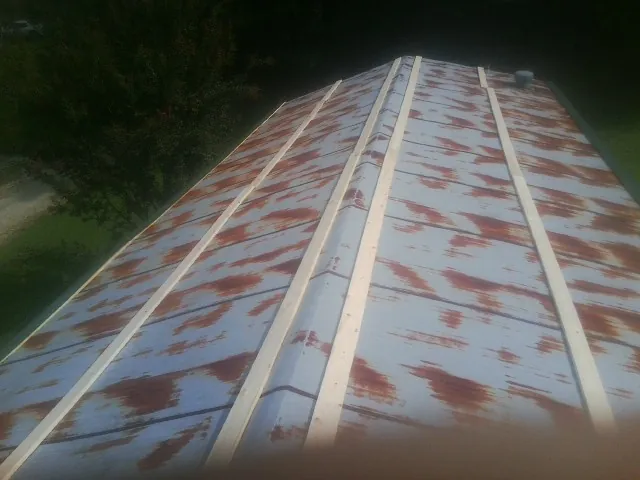 Rusted metal roof panels with new wood purlins before replacement — Storm Damage Roof Repair in Wellborn by Roofing Brothers